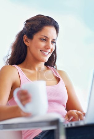 Photo for Woman, smile and coffee with laptop with reading digital blog and relax wellness in chair in home. Young person, happy and computer with espresso for online subscription and technology in apartment. - Royalty Free Image