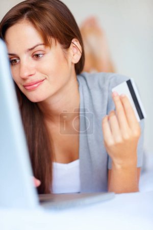 Photo for Home, woman and credit card with a laptop, ecommerce and connection with a smile, buying and payment. Person, bedroom or girl with a computer, online shopping and transaction with subscription or app. - Royalty Free Image