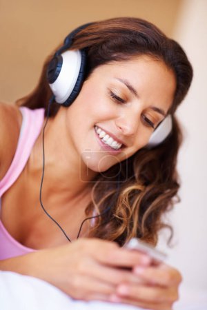 Photo for Smile, headphones and young woman listening to music, playlist or radio at home for entertainment. Happy, technology and female person from Canada relax and streaming song or album in her apartment - Royalty Free Image