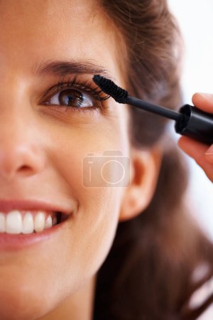 Photo for Woman, face and mascara with smile for beauty, cosmetics and facial skincare with glow or closeup. Person, happy and eye application with product or grooming for makeup, cosmetology and aesthetic. - Royalty Free Image