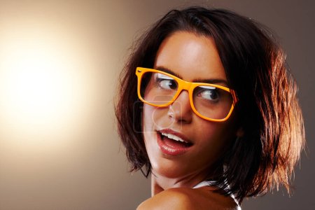 Photo for Woman, face and closeup with glasses in studio for vision, sight and trendy fashion mock up on brown background. Female model, confident or pose for wow, surprise or omg for cool, chic or spectacles. - Royalty Free Image