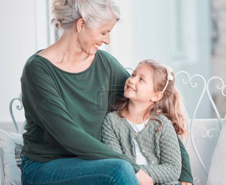 Photo for Senior grandmother, girl and happy on sofa with hug, care and bonding with love in family home lounge. Elderly lady, child and embrace with smile, relax and together on living room couch in house. - Royalty Free Image