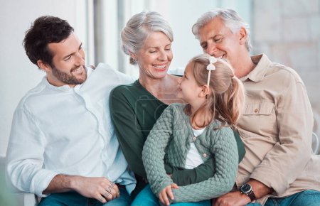 Photo for Grandparents, girl and happy with dad on sofa for hug, care or bonding with love in family home lounge. Elderly people, kid and father with smile, relax and conversation on living room couch in house. - Royalty Free Image