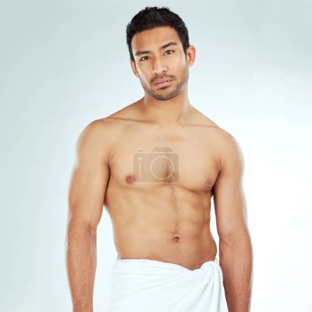 Photo for Chest, body and portrait of asian man in a towel in studio for cleaning, hygiene and care on grey background. Face, confidence muscular Japanese model with glowing skin grooming results after shower. - Royalty Free Image