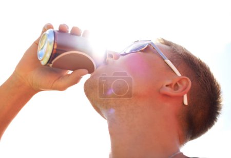 Photo for Man, drinking and beer with sunlight outdoor for concert, event or music festival with sunglasses and lens flare. Person, alcohol and beverage in summer for relax, freedom and enjoyment with sunshine. - Royalty Free Image