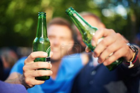 Téléchargez les photos : Les hommes au festival de musique avec acclamations, mains avec de la bière et excités dans la nature ensemble. Boire sur la bouteille, la célébration et les amis à la fête en plein air avec la liberté, l'aventure et les gens en vacances d'été - en image libre de droit