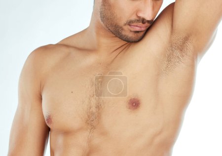 Photo for Body, closeup and man smelling armpit in studio for wellness, hygiene or control on white background. Underarm, care or guy model with sweat, scent or odor check after shower, cleaning or grooming. - Royalty Free Image