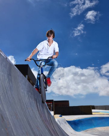 Photo for Riding, bike and teen on ramp for sport performance, jump or training for event at skatepark with sky mockup. Bicycle, stunt or kid balance on edge of board in trick for cycling competition challenge. - Royalty Free Image