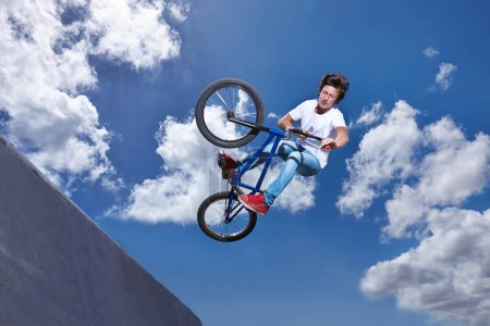 Téléchargez les photos : Rampe, saut et homme avec vélo dans le ciel au parc, événement ou compétition pour le sport avec risque et énergie. Maquette, espace et personne dans l'air avec astuce ou cascade à vélo pour s'amuser en été avec l'aventure. - en image libre de droit