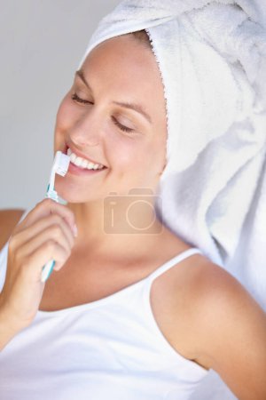 Foto de Mujer, cepillarse los dientes y sonreír para un cuidado saludable en el baño para la higiene bucal, encía dental o bienestar. Persona femenina, cepillo de dientes y rutina de blanqueamiento para ortodoncia, brillo oral o gingivitis brillo. - Imagen libre de derechos