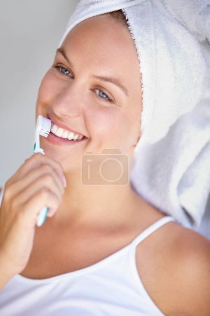 Foto de Mujer, cepillarse los dientes y sonreír para saludable en el baño para higiene bucal, encía dental o bienestar. Persona femenina, cepillo de dientes y rutina de blanqueamiento para ortodoncia, brillo oral o gingivitis brillo. - Imagen libre de derechos