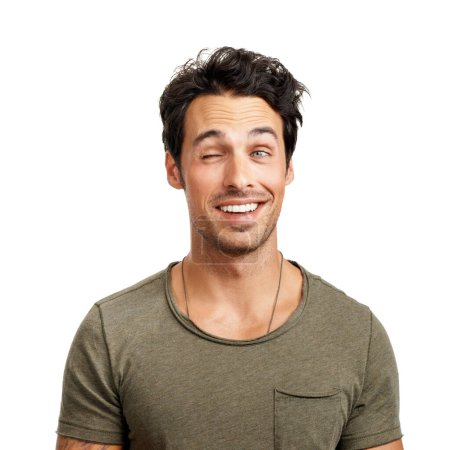 Photo for Face, smile and playful wink with a man in studio isolated on a white background for comedy or humor. Comic, funny and happy with a goofy young person acting silly as a character for a carefree joke. - Royalty Free Image