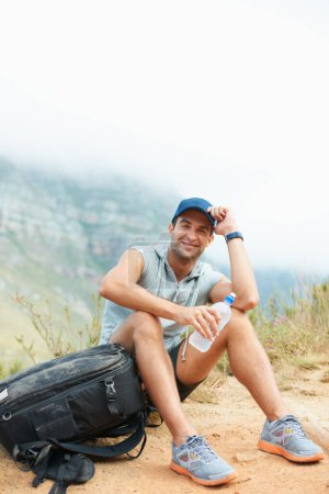 Photo for Portrait, hiking and happy with man in nature for health, trekking and adventure. Travel, explore and journey with person and water in mountain path for backpacking, relax and wellness vacation. - Royalty Free Image