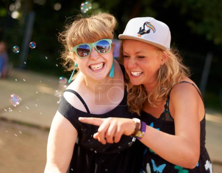 Photo for Smile, friends and portrait of bubbles outdoor in nature, fun game at festival or freedom in summer. Face, happy girls and women with soap, cool sunglasses at party celebration and pointing together. - Royalty Free Image