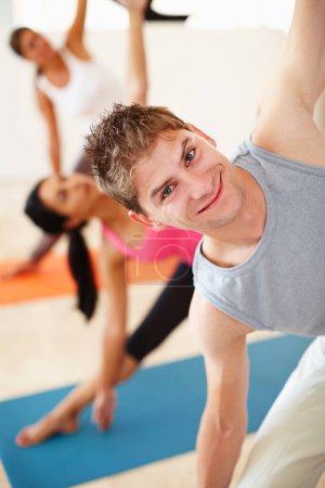 Photo for Portrait, smile and stretching, happy man in yoga class for fitness, commitment and body wellness. Pilates, men and women in gym together for holistic health, mindfulness and person at exercise club - Royalty Free Image