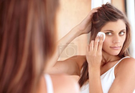 Photo for Skincare, cleaning and woman in mirror with cotton pad, makeup or dirt removal with luxury skin product in home. Dermatology, cosmetics and girl with beauty treatment, facial care or wipe in bathroom. - Royalty Free Image