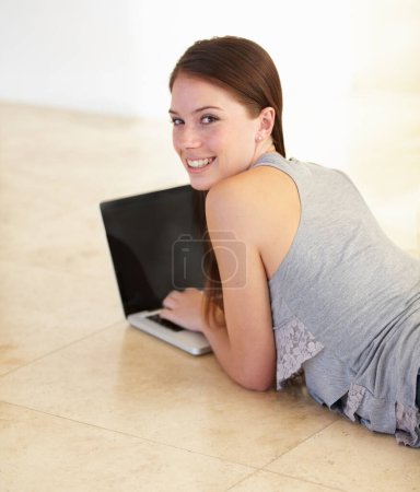 Photo for Woman, student on floor and laptop for e learning, online education and typing or search information on website. Portrait of young person relax with her computer for research or registration at home. - Royalty Free Image