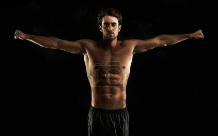 Photo for Arms raised, black background or topless man for workout, training or exercise in studio for fitness. Model, dark shadow or ripped male person with healthy body, six or stomach for wellness in Italy. - Royalty Free Image