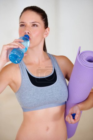 Photo for Health, fitness and young woman drinking water for pilates workout or exercise in gym. Nutrition, sports and thirsty female athlete enjoying hydration beverage for training at wellness class. - Royalty Free Image