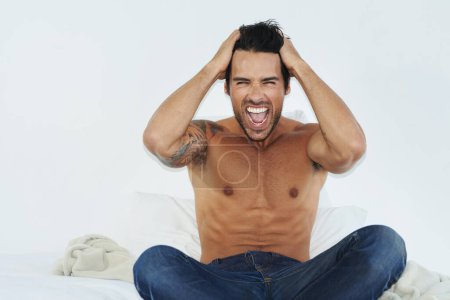 Photo for Stress, insomnia and screaming with a shirtless man on a bed in his home feeling frustrated or sleepless. Mental health, anxiety and burnout with the body of a young person shouting in a bedroom. - Royalty Free Image
