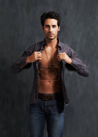 Photo for Handsome, fashion and portrait of man by a wall with trendy, cool and stylish outfit with confidence. Abs, attractive and young male model from Canada with casual shirt and jeans by gray background - Royalty Free Image