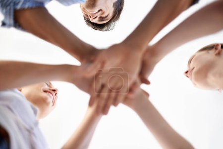 Photo for Low angle, huddle and solidarity by colleagues, hands and collaboration or support, unity and staff. People, meeting and brainstorming together, trust and planning or agreement in team building. - Royalty Free Image
