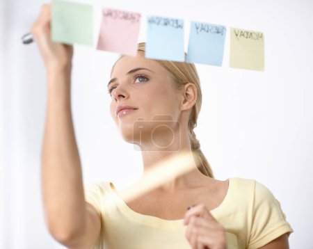 Photo for Business woman, writing and schedule planning on sticky notes or glass board for project or time management. Creative planner or worker with priority list, calendar or brainstorming of workflow ideas. - Royalty Free Image