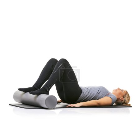 Photo for Pilates, foam roller and woman in core workout, exercise or wellness for sports rehabilitation on floor. Ground, mockup space and studio athlete fitness, training and lying on mat on white background. - Royalty Free Image
