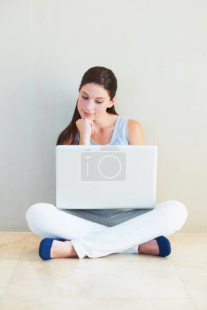 Photo for Woman, laptop and thinking for idea, decision or choice sitting against a wall at home. Female person freelancer in wonder, thought or planning for online research or communication on floor at house. - Royalty Free Image