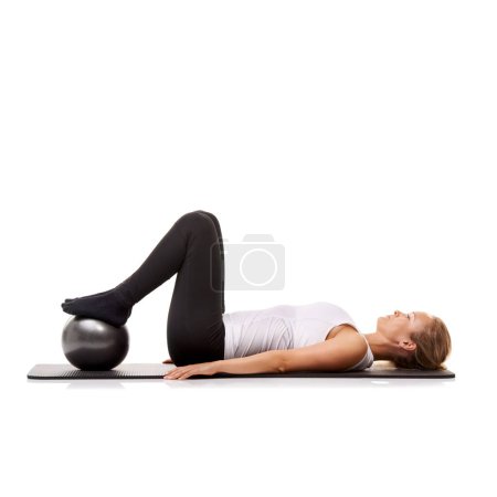 Photo for Yoga, exercise and woman on floor with ball for pilates, wellness care and health in studio. Gym, training and girl on mat with workout, lying and muscle fitness isolated on white background - Royalty Free Image
