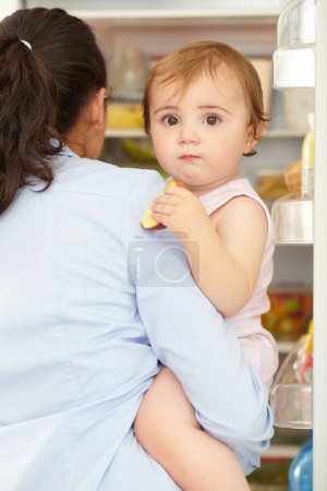 Photo for Portrait, woman and fruit of toddler in kitchen, open fridge and food for hunger in back view. Youth, little girl and hold snack for eating for nutrition in healthy vegan, vegetarian or diet in home. - Royalty Free Image