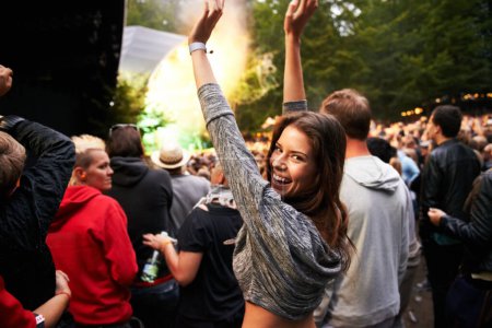 Photo for Happy woman, portrait and crowd in music festival for party, event or DJ concert in nature. Excited female person smile with hands up and audience at carnival, performance or summer fest outside. - Royalty Free Image
