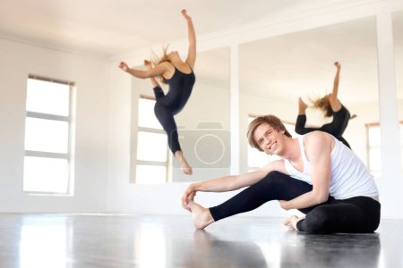 Photo for Ballet, studio and class stretching in exercise, practice for people and warm up for dancing. Fitness, training and dancers on floor preparing legs in workout for performance or action in academy. - Royalty Free Image