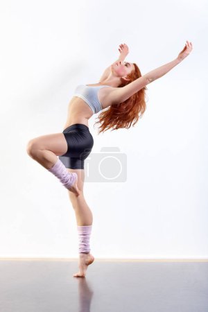 Photo for Woman, dancer and studio background for creative expression exercise, white wall as mockup space. Female person, aerobics and workout gymnastics or fit leap as talent energy, practice for training. - Royalty Free Image