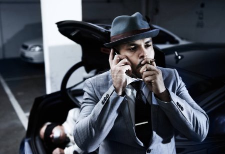 Photo for Smoking, car and man with hostage in trunk for negotiation, kidnapping ransom and phone call. Mafia, gangster criminal and business person in boot for abduction, danger and robbery in parking lot. - Royalty Free Image