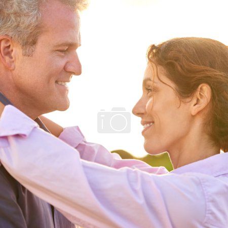 Photo for Old couple, smile and embrace at sunset with love, trust and support in marriage and retirement. Happy, woman and care for partner on holiday with freedom, health and wellness at the beach for cruise. - Royalty Free Image