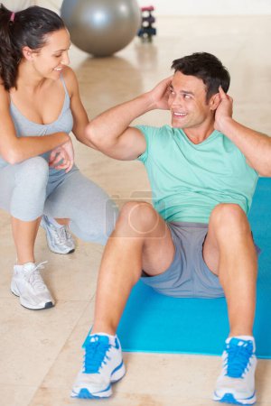 Photo for Couple, fitness and man sit up in exercise and workout for health, wellness and cardio together, People, training or woman helping person with core, crunches and pilates routine in gym with happiness. - Royalty Free Image