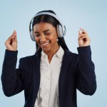 Headphones, dancing or happy businesswoman in studio for music isolated on blue background. Energy, smile or calm female person streaming a radio song, sound or audio on online subscription to relax.