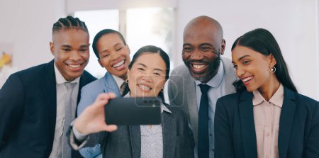Foto de Sonríe, selfies y gente de negocios feliz en la oficina para formar equipo o crear lazos. Colaboración, diversidad y grupo de amigos profesionales tomando una foto en el lugar de trabajo moderno - Imagen libre de derechos