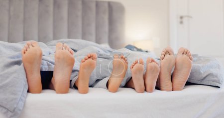Photo for Sleeping feet, relax and family in bed with love, bond or security at home together. Barefoot, children or parents in a bedroom with comfort, trust and care, protection or nap with safety in a house. - Royalty Free Image