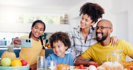 Photo for Selfie, breakfast and a black family eating in the kitchen of their home together for health, diet or nutrition. Food, photograph or memory with a mother, father and children together in an apartment. - Royalty Free Image