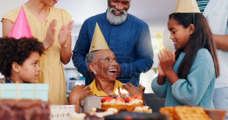 Foto de Pastel, feliz y la familia en la fiesta de cumpleaños celebran juntos en la casa moderna con velas. Sonríe, emocionado y niños pequeños con padre africano y abuelos con sombrero de postre dulce en casa - Imagen libre de derechos