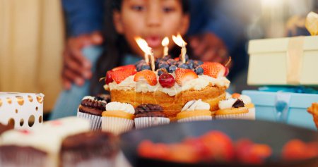 Photo for Happy birthday, cake and candle light in celebration with family for party, holiday or special day at home. Closeup of little girl blowing flame for wish in growth, love or care and bonding at house. - Royalty Free Image