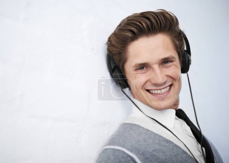 Photo for Business man, portrait and headphones by wall background for music, smile and listening to radio. Employee, person and happy with audio streaming, sound or subscription for podcast by mockup space. - Royalty Free Image