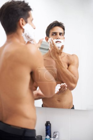 Téléchargez les photos : Homme, crème à raser et application dans le miroir pour l'épilation dans la salle de bain, la beauté et le bien-être. Homme, soins de la peau et cosmétiques ou nettoyage dans la routine du matin, toilettage et réflexion à la maison. - en image libre de droit