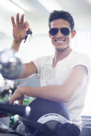Photo for Handsome man, portrait and motorcycle keys with helmet and sunglasses for transportation vehicle in garage. Young male person or biker smile for cool automobile or ownership of mechanical motorbike. - Royalty Free Image