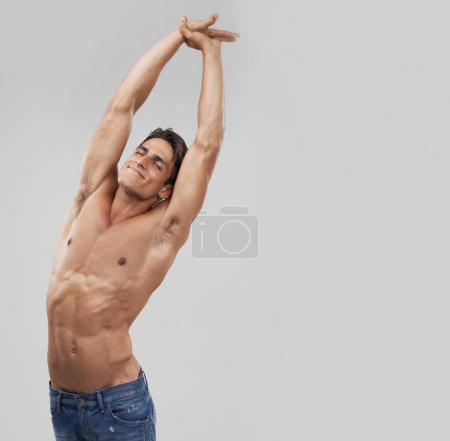 Photo for Man, stretching and fitness pride in studio, relaxing and smiling by gray background. Male person, wellness and confidence for healthy body, muscle development and results or progress by mockup space. - Royalty Free Image