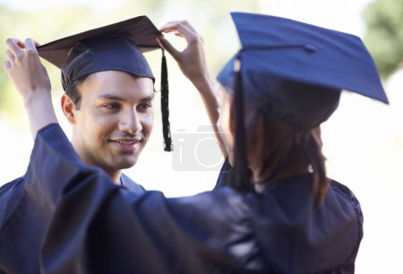 Photo for Couple, graduate and woman fix man graduation cap, education and academic success with ceremony. Certification, achievement and event at university with people together for milestone and award. - Royalty Free Image