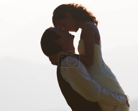 Photo for Groom lifting bride, silhouette and wedding outdoor, hug with love and commitment in marriage. Man, woman and happiness, celebration and social event with mockup space, romance and life partner. - Royalty Free Image