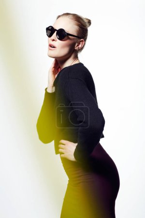 Photo for Woman, sunglasses for fashion and light streak, cosmetics or makeup with creativity and neon glow on white background. Art deco, beauty and bright color in studio, glamour and dark eyewear with style. - Royalty Free Image